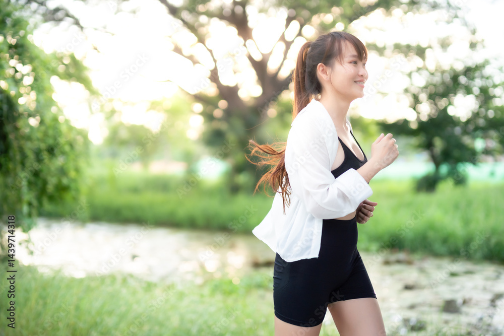 Portrait of beautiful asian Young woman in white robe wearing sportswear jogging working out outside. training on public equipment in outdoor at park. concept Exercise Healthy lifestyle.