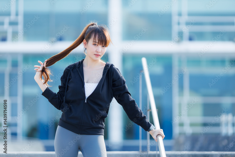 Portrait of beautiful asian Young woman in Black robe sportswear working out outside. training on public equipment in outdoor at park. concept Exercise Healthy lifestyle.