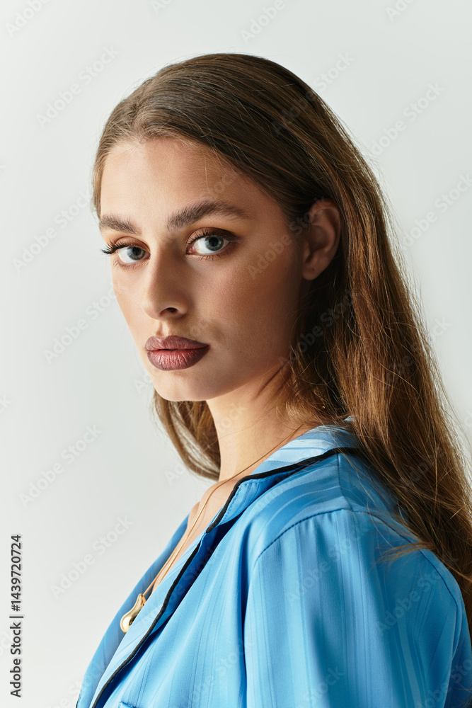Young woman with stunning blue eyes poses in a stylish outfit for a modern indoor shoot Young woman with stunning blue eyes poses in a stylish outfit for a modern indoor shoot