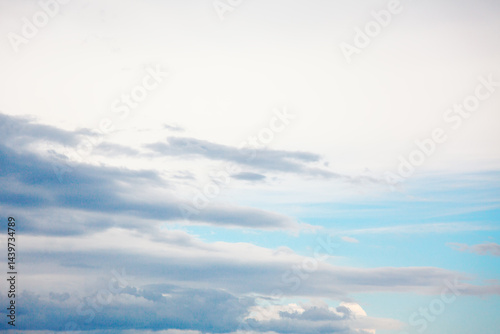 Obraz na płótnie Serene sky with gentle gradient of colors transitioning from soft whites at the top to deep blues below. Wispy clouds stretch across the expanse, varying in texture and density w salonie