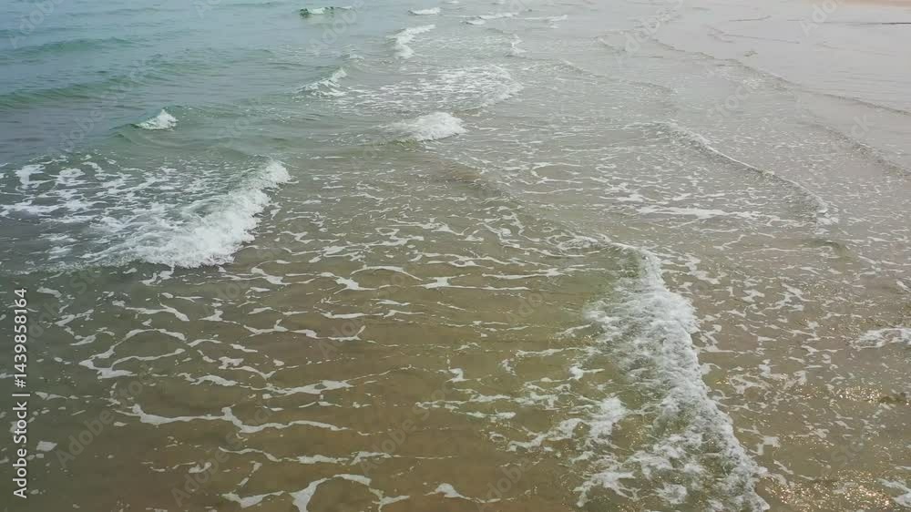 Coastal waves gently lap at the shore under the traverser during a calm afternoon