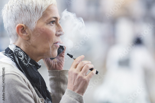 Senior female using electronic cigarette