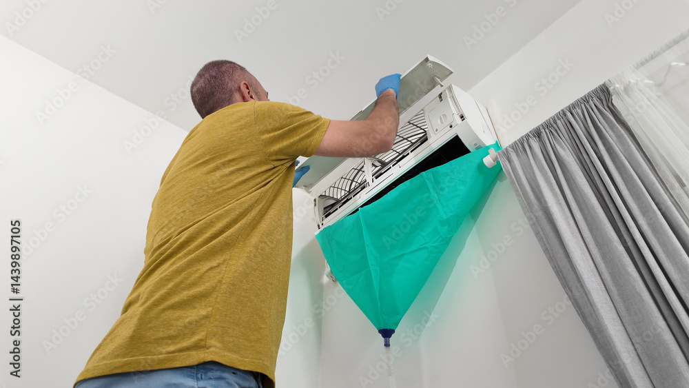 Man cleaning and maintaining air condition unit at Man cleaning and maintaining air condition unit at home.