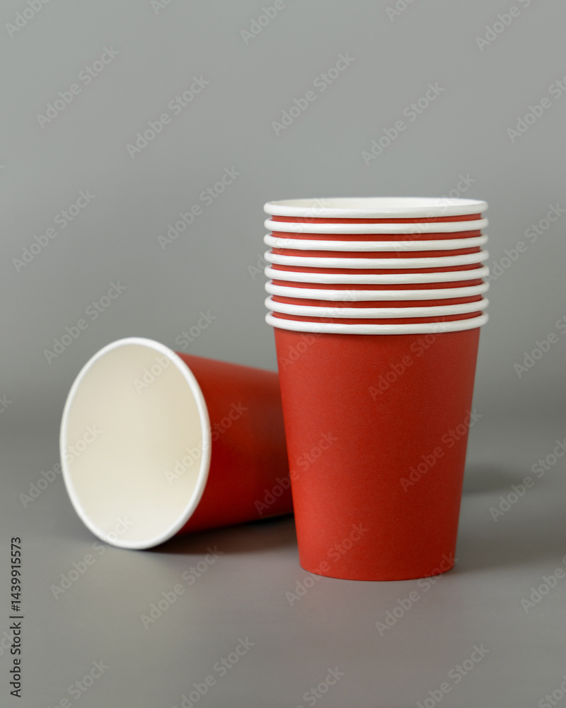 Disposable red paper cups on a gray closeup, mockup. No plastic and sustainable Christmas