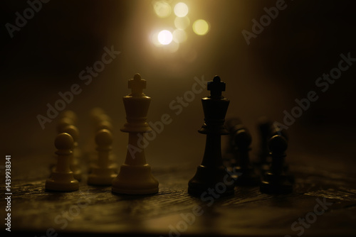 Obraz na płótnie White and Black Chess Pieces on a Wooden Board with Warm Lighting in the Background w salonie