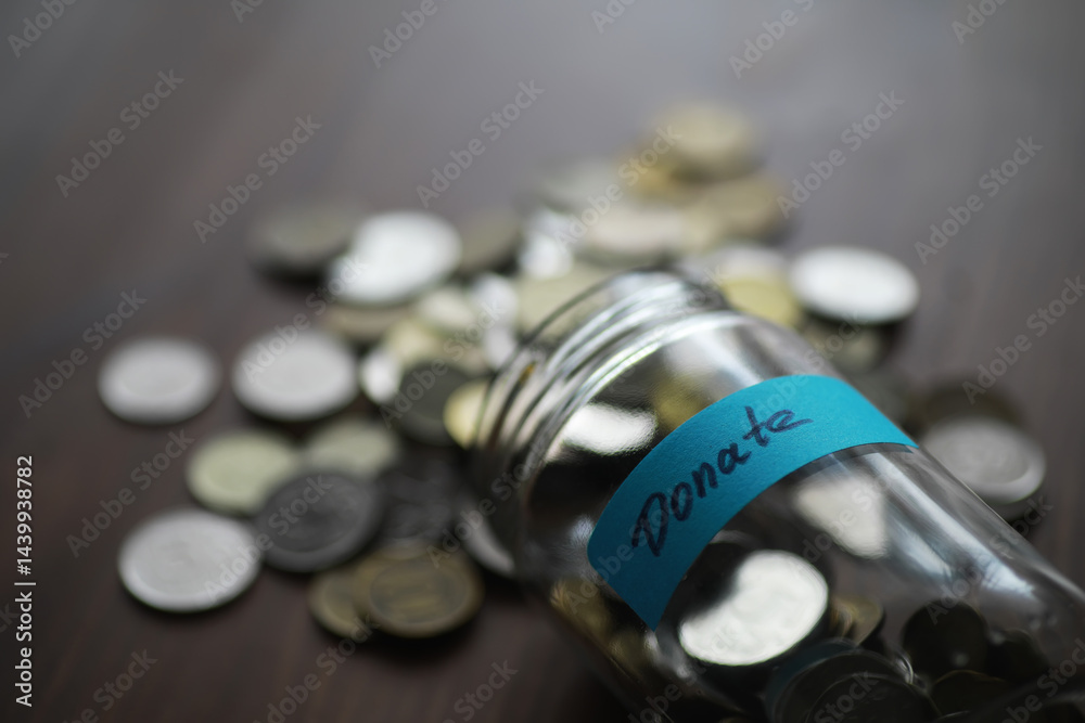 Donation Jar with Coins Spilling Over on Table - Concept of Charity, Philanthropy, and Generosity