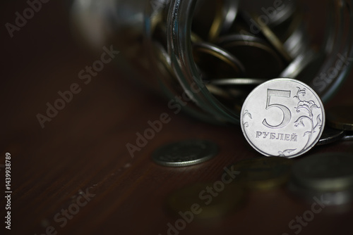 Obraz na płótnie Russian 5 Ruble Coin Spilling from a Glass Jar with Multiple Coins on Wooden Surface w salonie