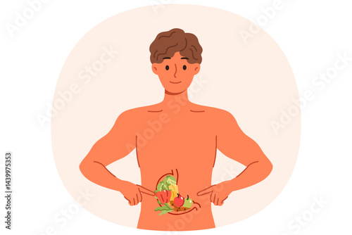 Obraz na płótnie Man recommends healthy diet, points to vegetables inside stomach, stands with naked torso. Diet guy explains benefits of eating fresh produce from farmer market or organic section of supermarket w salonie