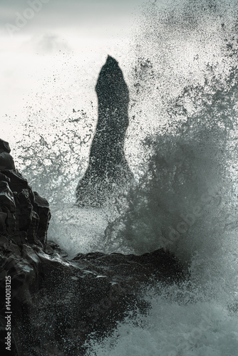 Basaltsäulen und Felsnadel im Meer bei Reynisfjara, Island.