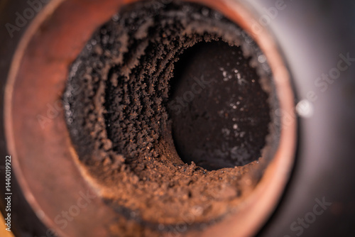 Pipe in the wall for connecting a fireplace. Chimney pipe in the wall, close-up. Soot on the inside of the pipe, maintenance and cleaning