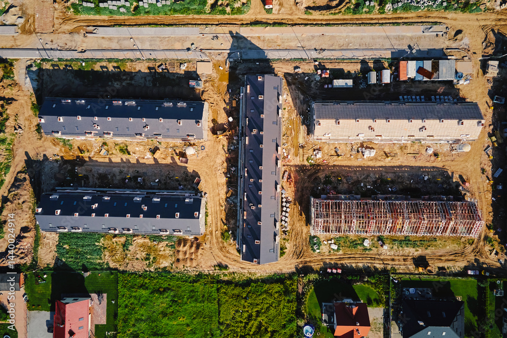 Aerial view of large housing estate under construction with modern residential buildings in small town. Suburban neighborhood