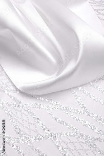 White bridal crystal lace and mikado brocade satin on white background. Flatlay featuring bridal textile ideal for wedding creations, with luxurious white shiny lace.