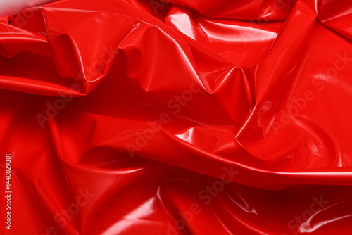 Sleek and glossy red patent artificial leather with a reflective surface. Its smooth, polished texture showcases modern elegance, ideal for fashion, upholstery, and high-end accessories.
