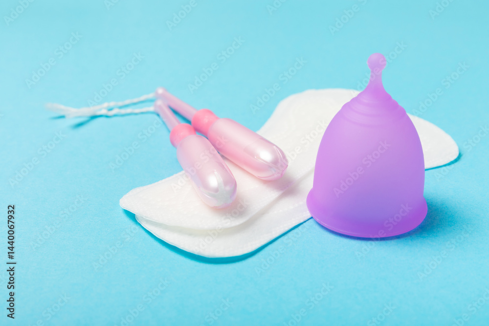 Menstrual cup on a bright background. Sanitary napkins, tampons and menstrual cup.Concept of critical days, menstruation.feminine hygiene product. Women health concept.Premenstrual syndrome.Copy space