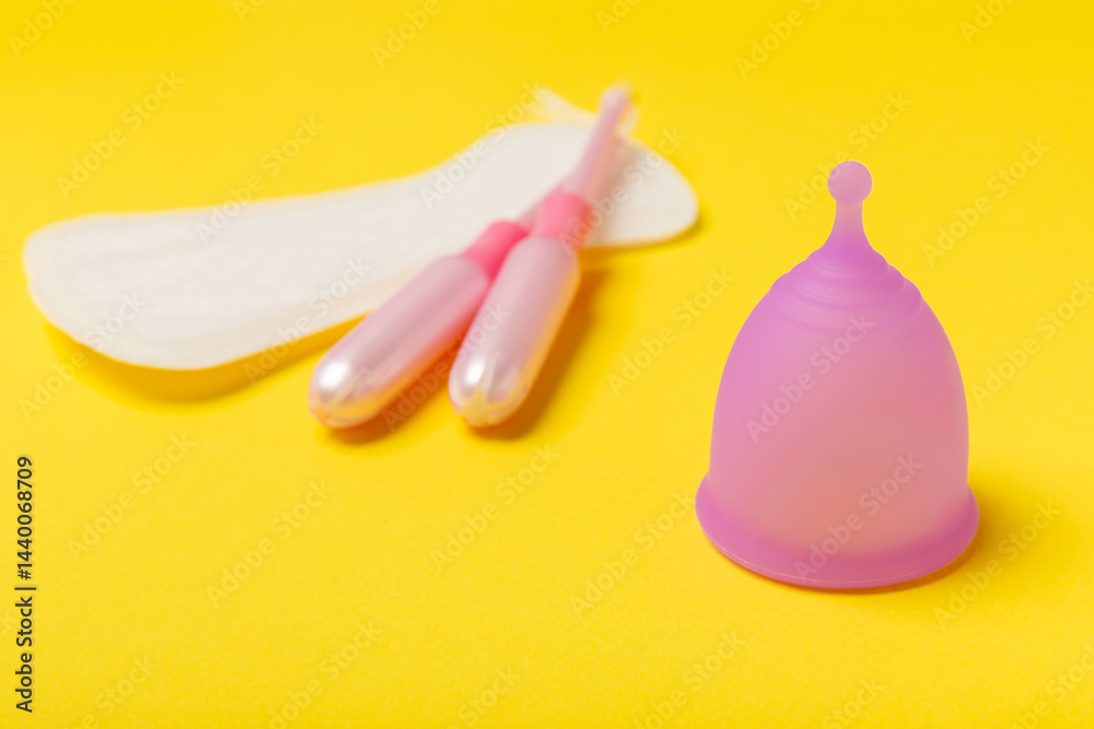 Menstrual cup on a bright background. Sanitary napkins, tampons and menstrual cup.Concept of critical days, menstruation.feminine hygiene product. Women health concept.Premenstrual syndrome.Copy space
