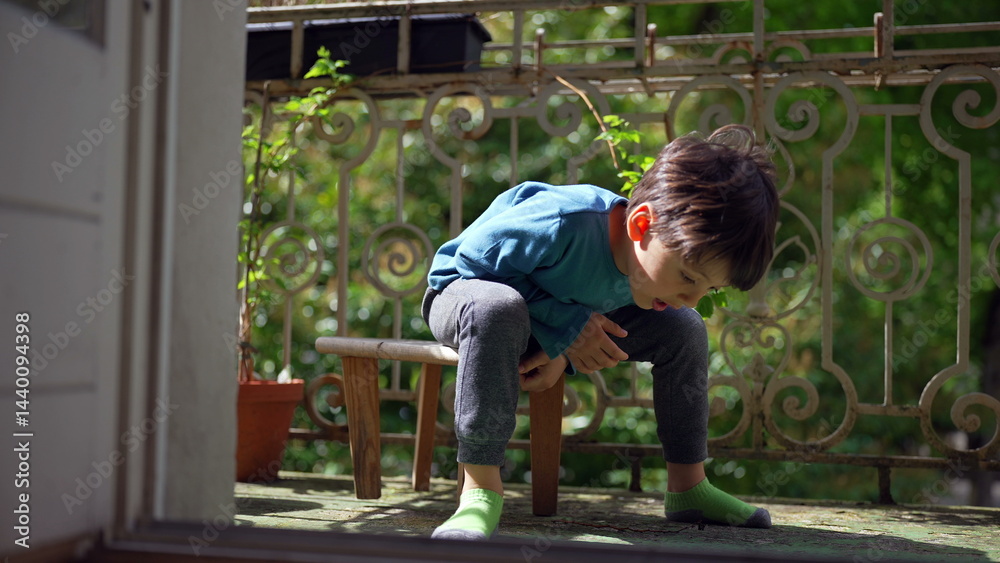 Young boy sitting on a small stool on the balcony, deep in thought, enjoying a sunny day outdoors. a quiet, introspective moment of a child reflecting in a serene environment Young boy sitting on a small stool on the balcony, deep in thought, enjoying a sunny day outdoors. a quiet, introspective moment of a child reflecting in a serene environment