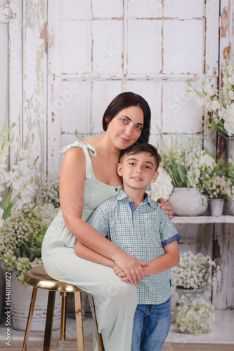mother and son in green house posing for Mother's Day photos 