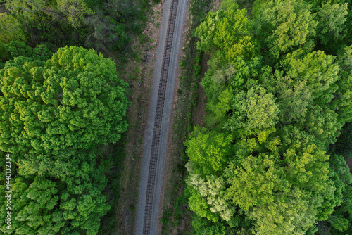Top down view of railroad tracks surrounded by dense tree growth