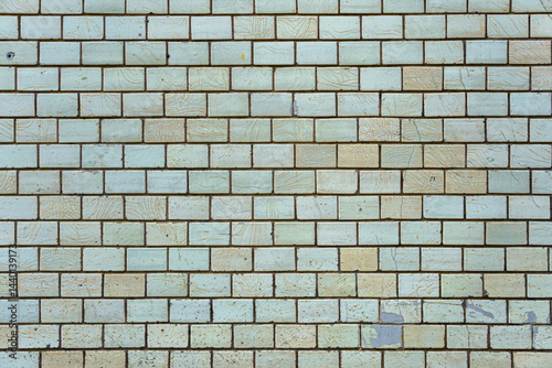 Wall of vintage bricks covered with cracked glaze. Bricks are arranged in a pattern.