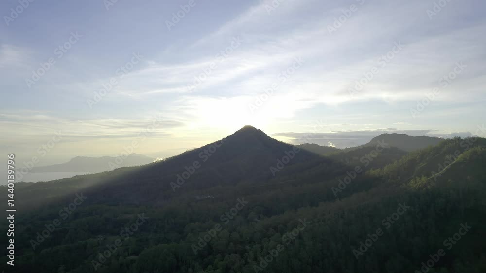 Drone captures a dramatic sunset behind a mountain, creating a soft silhouette and casting a long shadow across the landscape, revealing depth and contrast in golden hour light. Drone captures a dramatic sunset behind a mountain, creating a soft silhouette and casting a long shadow across the landscape, revealing depth and contrast in golden hour light.