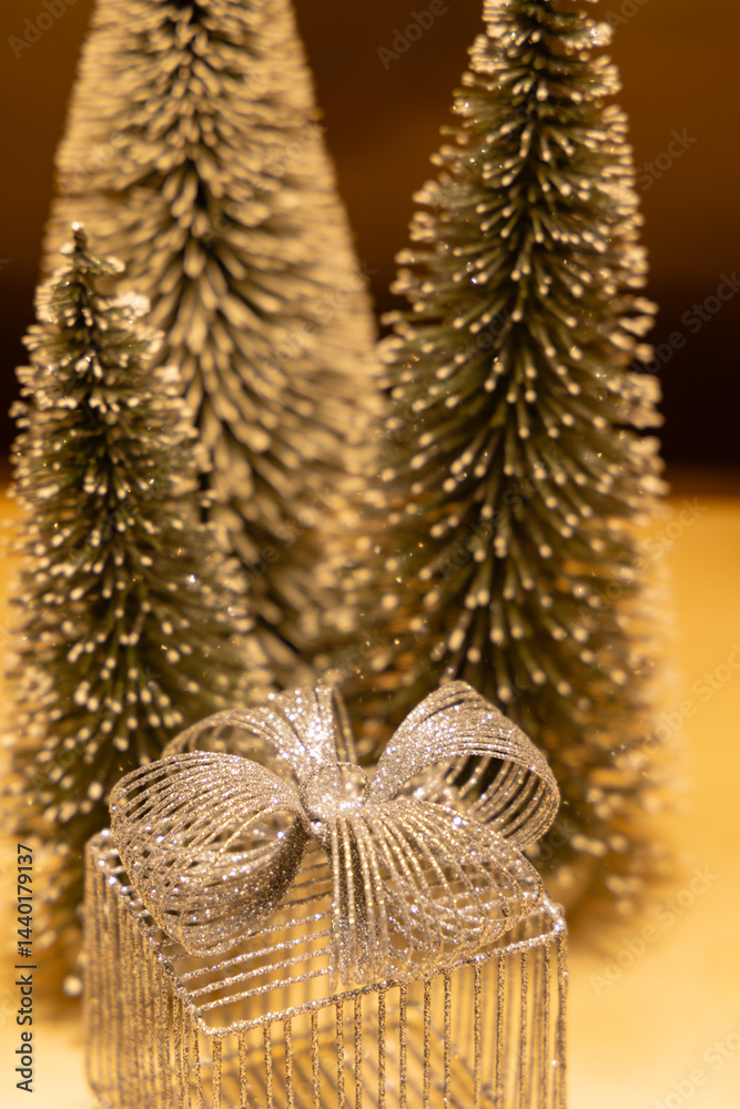 Silver christmas gift and decorative christmas trees creating festive atmosphere