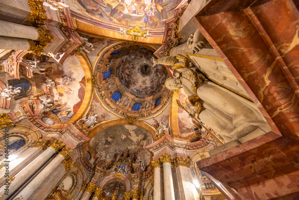 Statue overlooking the frescoes and dome of St. Nicholas Church in Prague
