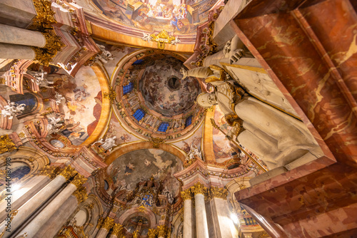 Obraz na płótnie Statue overlooking the frescoes and dome of St. Nicholas Church in Prague w salonie