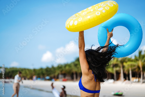 Obraz na płótnie Excited young woman enjoying her tropical beach vacation and celebrating a fun-filled summer getaway w salonie