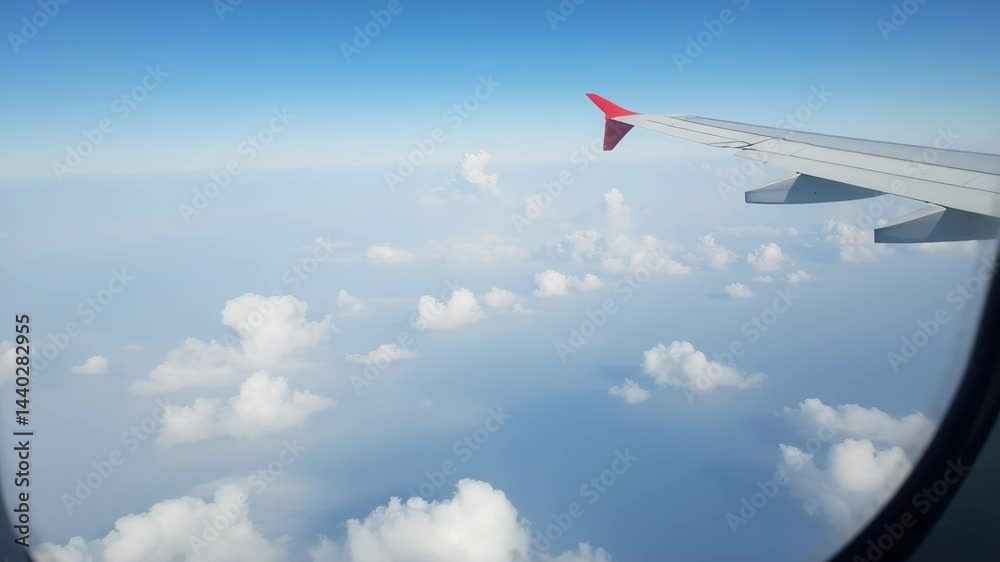 Beautiful view from an airplane window showing clouds and blue sky during a sunny day Beautiful view from an airplane window showing clouds and blue sky during a sunny day