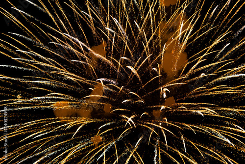 Spectacular golden fireworks show in night sky, shining sparks and trails perfect for celebration and backgrounds