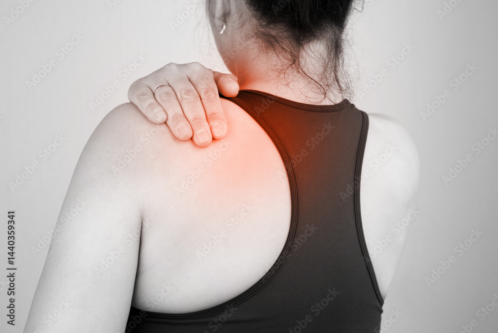 Woman with neck and back pain rubbing painful area of