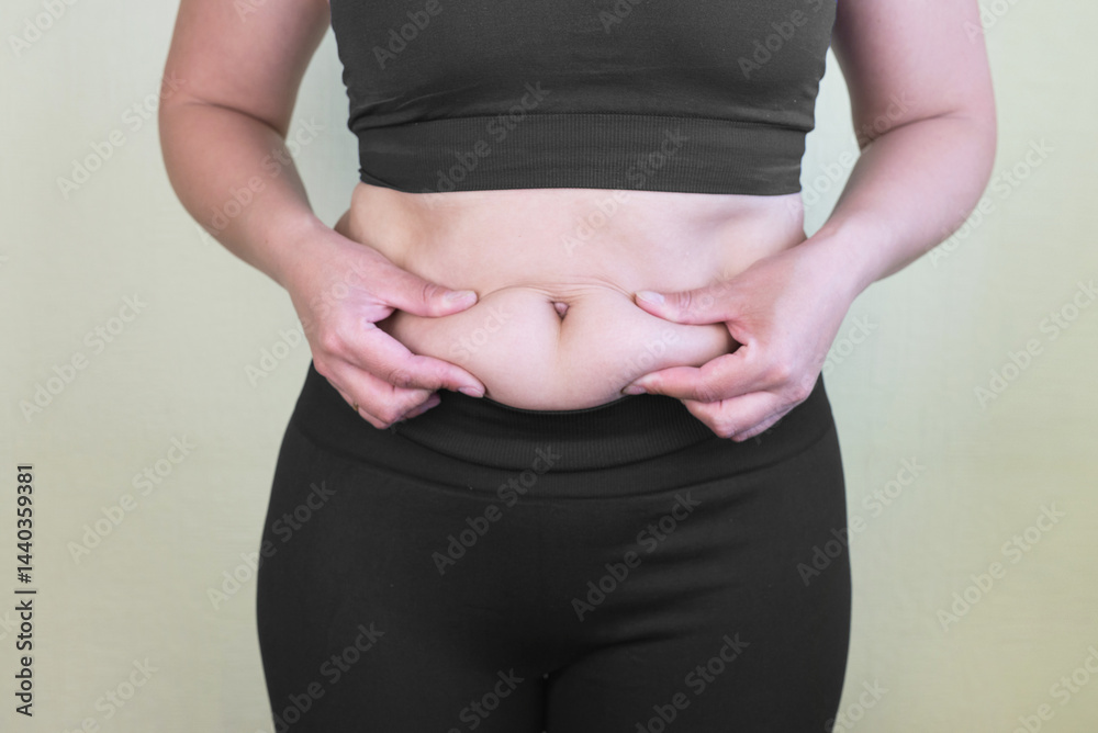 Women body fat belly. Obese woman hand holding excessive belly fat.