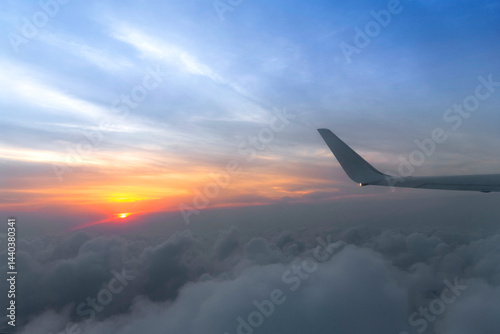 Obraz na płótnie Wing of the air plane on the sea of cloud sunset sky background from window airplane w salonie