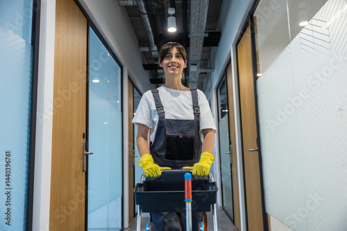 Wallpaper Mural Dark-haired young woman in uniform with a cart of cleaning equipment Torontodigital.ca
