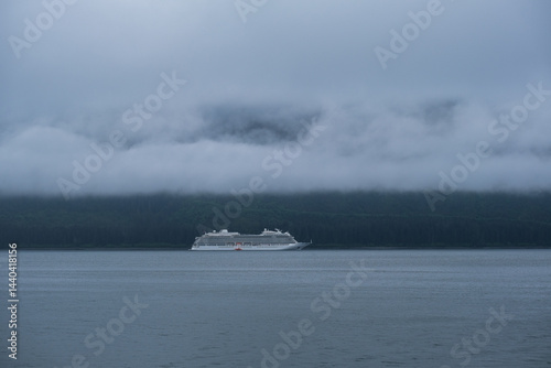 Obraz na płótnie Luxury cruiseship cruise ship liner Orion and kayaks boat in Hoonah Icy Strait Point Bay, Alaska with low hanging clouds and nature landscape scenery w salonie