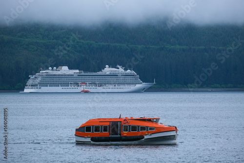 Obraz na płótnie Luxury cruiseship cruise ship liner Orion and kayaks boat in Hoonah Icy Strait Point Bay, Alaska with low hanging clouds and nature landscape scenery w salonie