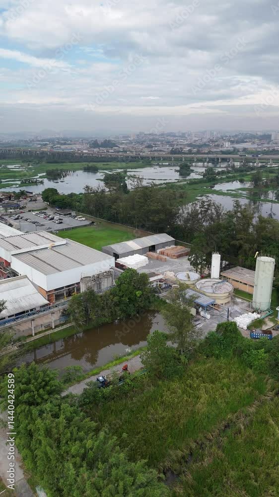 Visão aérea vertical mostra uma grande indústria de papel em operação, com linhas de produção, maquinário pesado e infraestrutura robusta, destacando a escala e tecnologia da fábrica