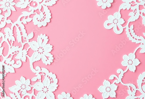 Delicate white lace overlaying a soft pink background, intricate floral pattern, wedding, dress