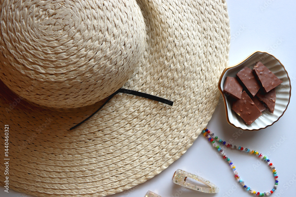 Glass of cocktail, straw hat, sunglasses, books, fresh fruit, chocolate and accessories. Summer essentials on the table. Top view.