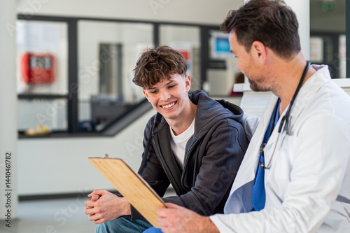 Quadro su tela Teenage boy smiling talking with doctor, receiving positive health news