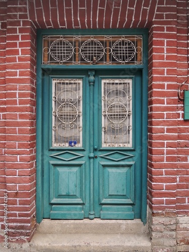 A traditional wooden blue door in a picturesque village in kalopanagiotis  Cyprus. The door is made of wood and shows natural wear and tear from time  offering authentic architecture and a sense of hi
