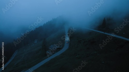 Aerial Drone View Cars Driving Winding Road in Fog and Darkness Remote Mountain Landscape Headlights Piercing Mist Solitary Night Journey