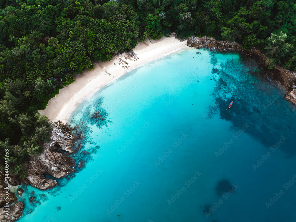 Aerial view of Banana Beach, Phuket, Thailand, with turquoise water, white sand, and lush tropical forest.