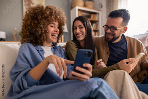 Quadro su tela Young Multicultural Friends In Casual Attire Share Entertaining Mobile Content W