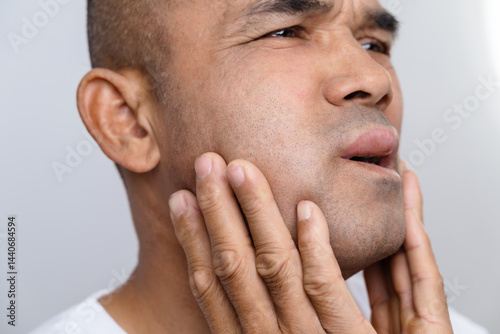 The man has facial swelling due to an allergic reaction to triggers such as insect bites stings
