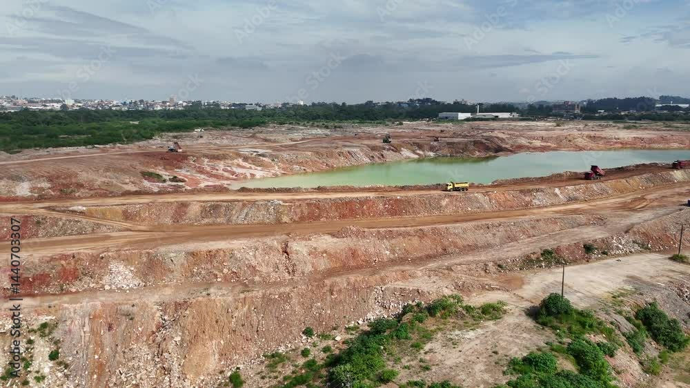 Caminhões pesados trabalhando em uma mineradora, transportando minério. A imagem captura o processo de extração mineral com grandes veículos industriais em plena operação na mineração a céu aberto