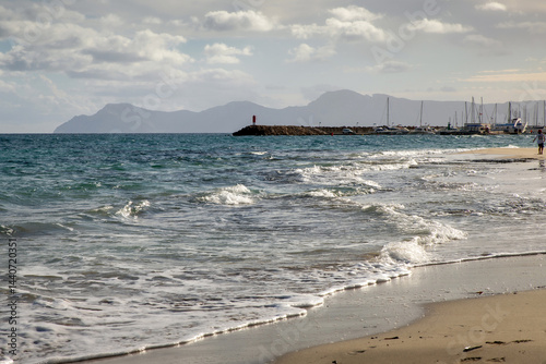 Fototapeta Naklejka Na Ścianę i Meble -  Mediterranean beach on the island of Majorca, or Mallorca on Balearic Sea, are part of Spain. Island in the Mediterranean Sea. Seaside vacations, clouds, seascape. View of the sea and the island.  