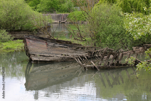 Obraz na płótnie Bow of th sunken ship called BURCIO or BURCHIO in italian language in the BURCI CEMETERY a place in the bend of the river SILE in Italy with wrecks of wooden boats used for the transport of Good w salonie