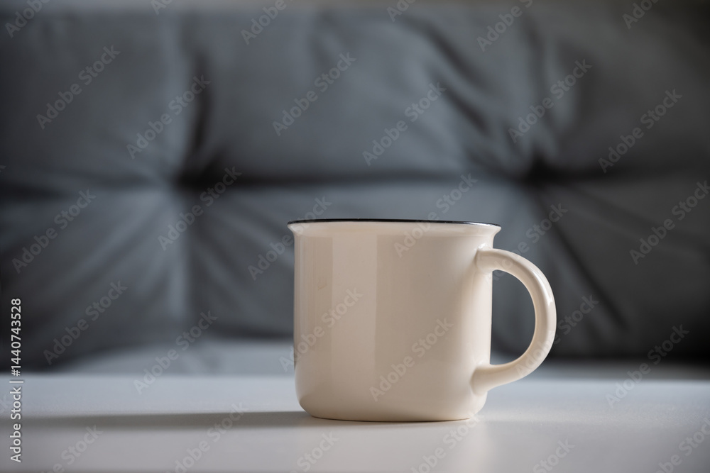 White mug on white table at home interior in living room. Beverage. Mockup. Perfect for businesses selling mugs, overlay your design on to image.