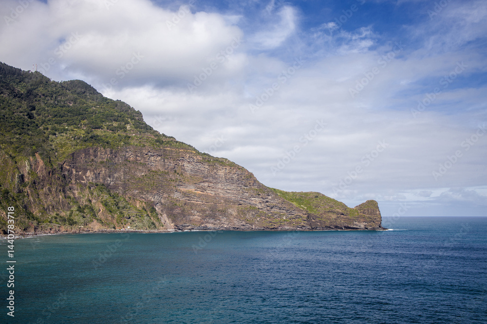 Majestic cliffs meet tranquil waters on the coast of Madeira Island, showcasing natural beauty and serenity in a breathtaking landscape